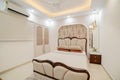 Indian Traditional Guest Bedroom Design with Curved Upholstered Bed Frame and 2-Door Wardrobe